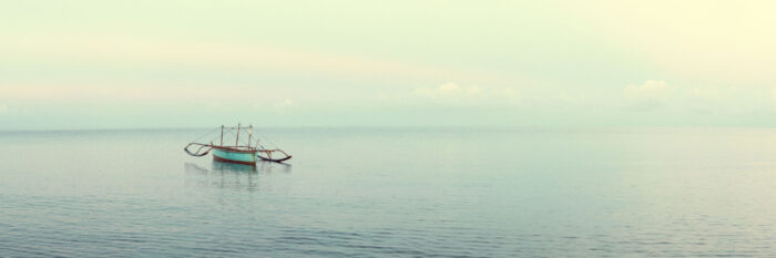 Fishing boat in the vast calm ocean