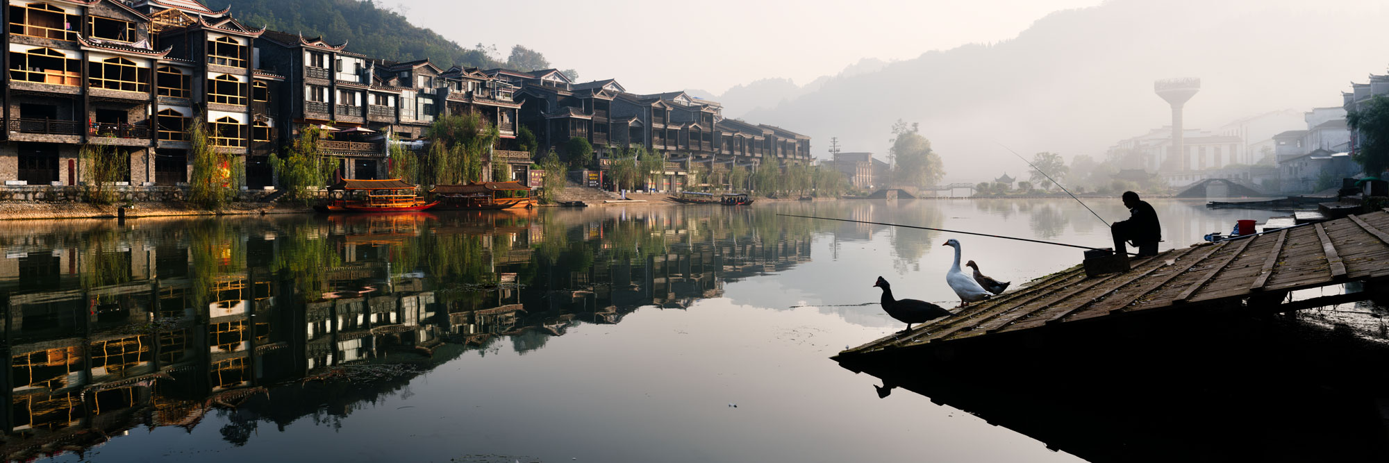 Panorama of Fenghuang Old Town fishing in the morning mist