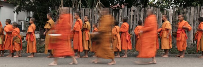 Young Buddhist Monks as they form a line to begin the alms giving ceremony in Laos
