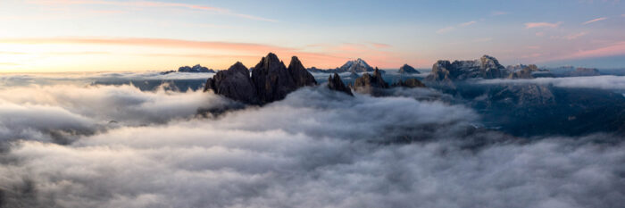 Aerial Panorama of the Dolomite mountains in Italy at sunrise during a cloud inversion