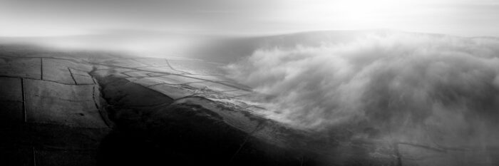 a panoramic print as fog passes through the Yorkshire Dales in black and white