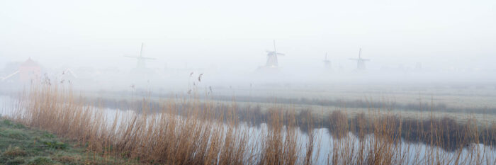 Panorama of the Zaanse Schans Windmills on a misty morning in The Netherlands