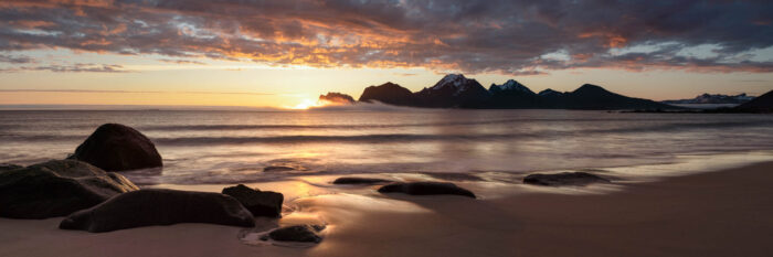 Panorama of the midnight sun at Storsandnes beach at sunrise in the Lofoten Islands