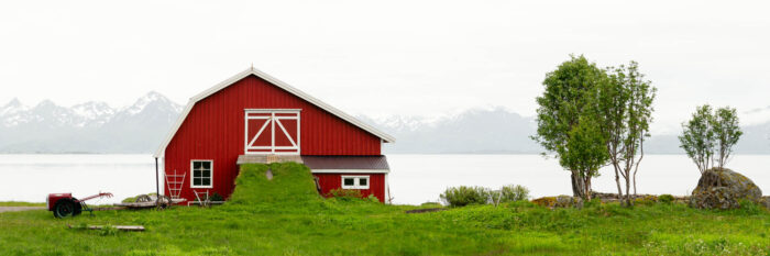 Panorama of a red barn on the Coast of Langøya Island in Vesterålen with the Lofoten Mountains behind