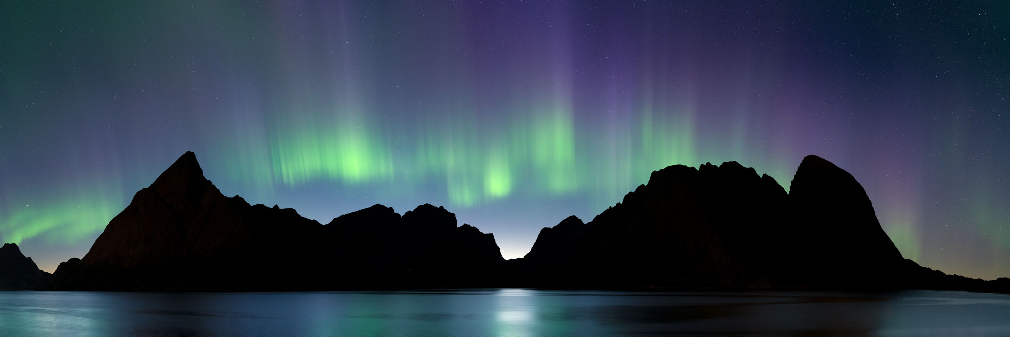 Panorama of the Northern Lights above the mountains in the Lofoten Islands