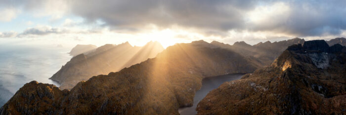 Aerial panorama of the sun beaming through the clouds in Moskenesoya in the Lofoten Islands