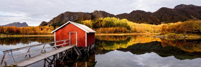 Panorama of a Red Norwegian Rorbu Fishing cabin on a Fjord in Nordland