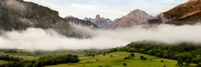 Panorama of the Picos de Europa as sunrise as the mist clears