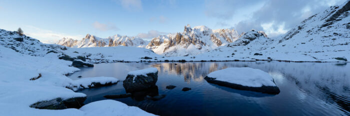Panorama of Lac Long and Massif des Cerces covered in snow in winter in the Vallée de la Clarée, French Alps