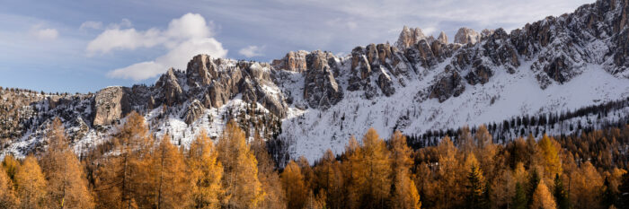 Panorama of the Lastoni di Formin steap west face Dolomia sprouting from the autumn meadows at sunset in the Dolomites, Italy