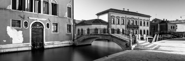 Monochrome panorama of a bridge over a canal in Venezia, Italy