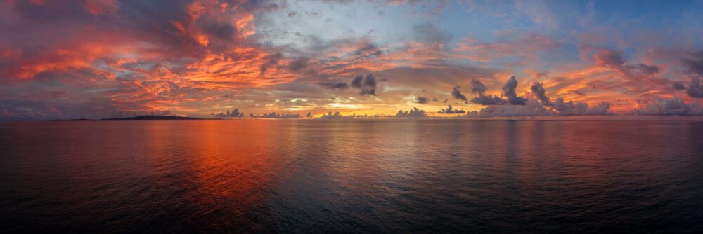 Panoramic art print of a beautiful red sunset over the open ocean in Okinawa Japan