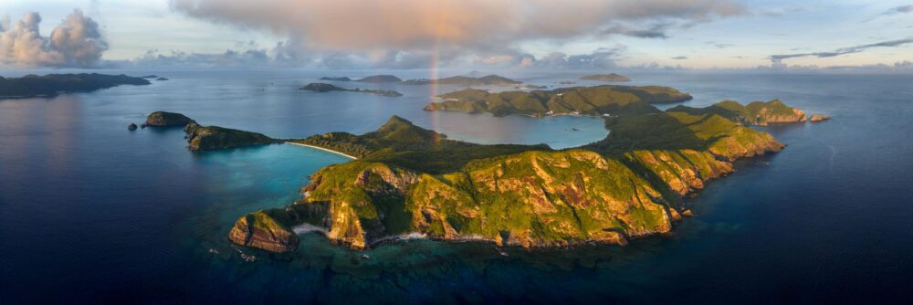 Aerial panoramic art print of a rainbow over Zamami and the Kerama Islands in Okinawa, Japan.