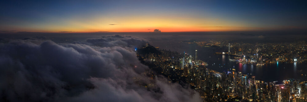 Aerial Panorama above the clouds in Hong Kong during sunset
