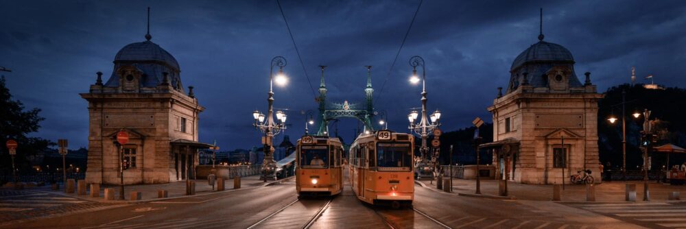 Panorama art print of Trams passing over the Azabadsag HId Bridge in Budapest at night