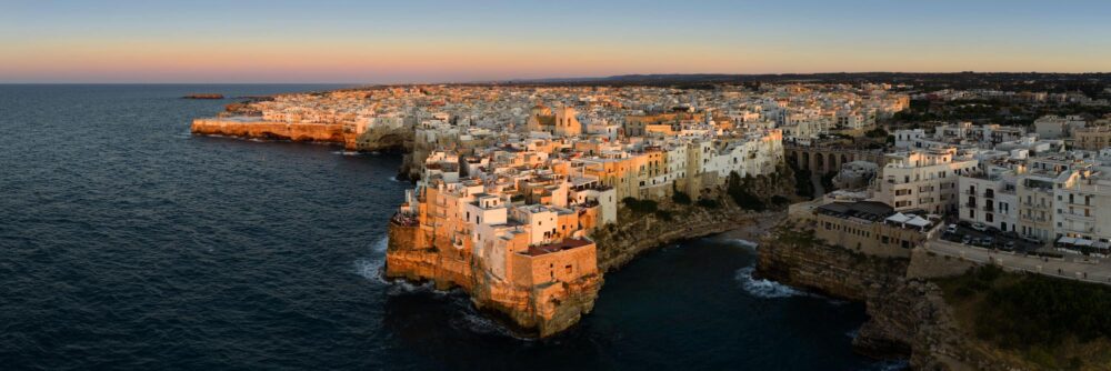 Aerial Panorama of town of Polignano a Mare along the Adriatic Coast in Italy during golden hour